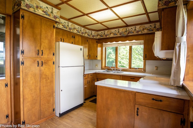 3193 W 112th St, Grant, MI 49327 - kitchen with white appliances, light wood-type flooring, brown cabinetry, decorative backsplash, and light countertops