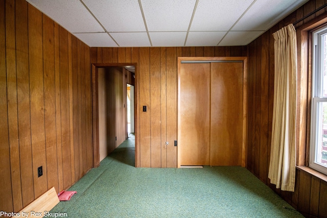 3193 W 112th St, Grant, MI 49327 - unfurnished bedroom featuring carpet flooring, wooden walls, a closet, and a drop ceiling