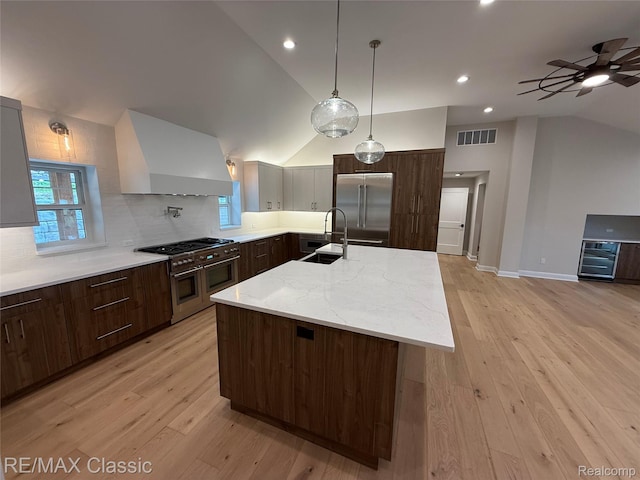 1420 Pettibone Lake Rd, Highland, MI 48356 - kitchen with high end appliances, wall chimney exhaust hood, vaulted ceiling, wine cooler, and ceiling fan