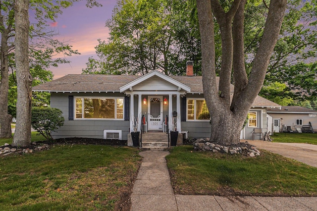 101 E Whittier St, Ludington, MI 49431 - view of front of home with a chimney, a front yard, and roof with shingles