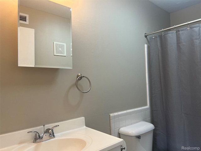 3901 Fort St Unit 202, Riverview, MI 48183 - full bath featuring vanity, a shower with shower curtain, wainscoting, and tile walls