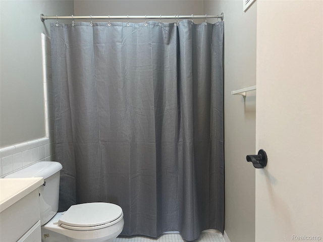 3901 Fort St Unit 202, Riverview, MI 48183 - full bath with vanity, a shower with curtain, a wainscoted wall, and tile walls