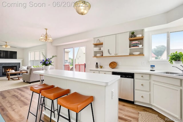 3244 Buckhorn Ct, Ann Arbor, MI 48105 - kitchen with stainless steel dishwasher, open shelves, a kitchen island, light countertops, and a warm lit fireplace