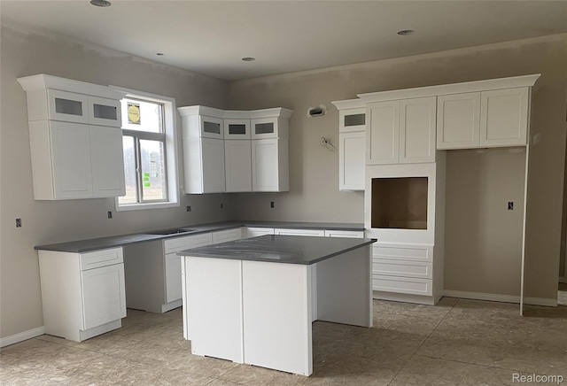 4940 Daisy Ln, Almont, MI 48003 - kitchen featuring a center island, white cabinets, glass insert cabinets, and dark countertops