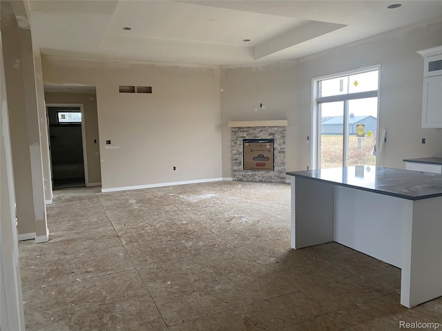 4940 Daisy Ln, Almont, MI 48003 - unfurnished living room featuring a tray ceiling and a fireplace