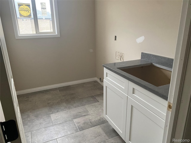 4940 Daisy Ln, Almont, MI 48003 - laundry room with baseboards and stone finish flooring