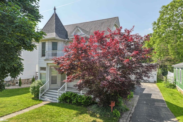 320 E Main St, Flushing, MI 48433 - victorian-style house featuring covered porch, a front yard, a garage, a shingled roof, and driveway