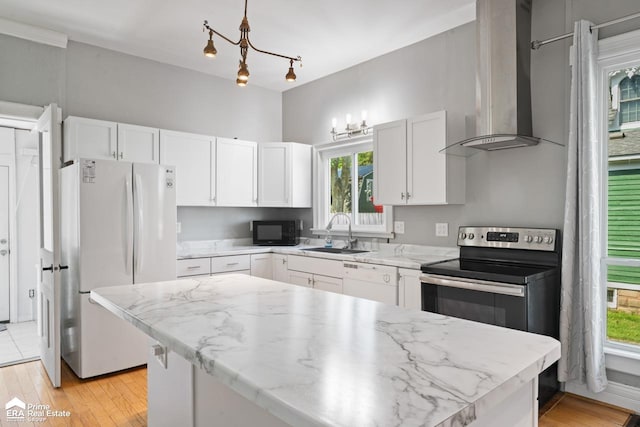 320 E Main St, Flushing, MI 48433 - kitchen featuring wall chimney exhaust hood, white appliances, white cabinetry, and plenty of natural light