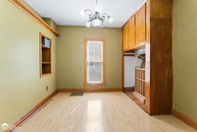 320 E Main St, Flushing, MI 48433 - unfurnished dining area featuring light wood-style floors and a chandelier