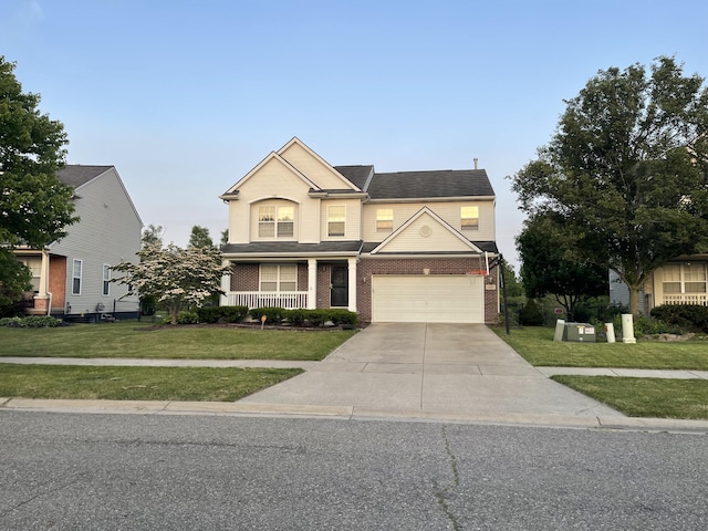 1735 Savannah Ln, Ypsilanti, MI 48198 - traditional home with concrete driveway, a front yard, brick siding, a garage, and covered porch