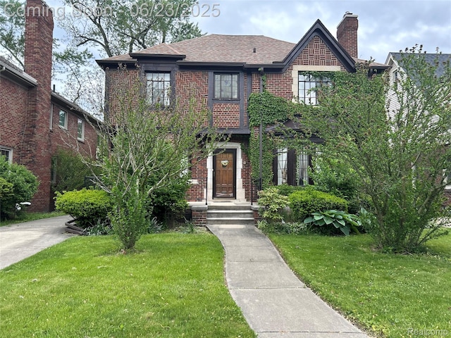 18430 Fairfield St, Detroit, MI 48221 - view of front of home featuring a front yard, brick siding, roof with shingles, and a chimney