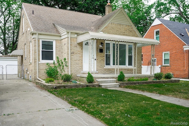 1922 N Wilson Ave, Royal Oak, MI 48073 - view of front facade with a chimney, a shingled roof, brick siding, and a front yard