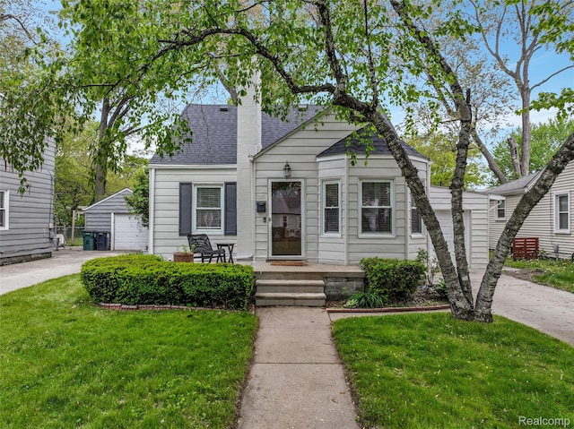 1605 N Vermont Ave, Rochester, MI 48067 - view of front of home with an outdoor structure, a front yard, a detached garage, a shingled roof, and a chimney