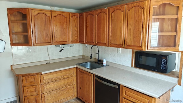 5157 Niagara St, Wayne, MI 48184 - kitchen featuring dishwashing machine, black microwave, decorative backsplash, and brown cabinets
