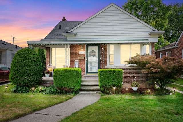 11372 Riverdale Ave, Redford, MI 48239 - bungalow featuring brick siding, a front yard, a chimney, and a shingled roof