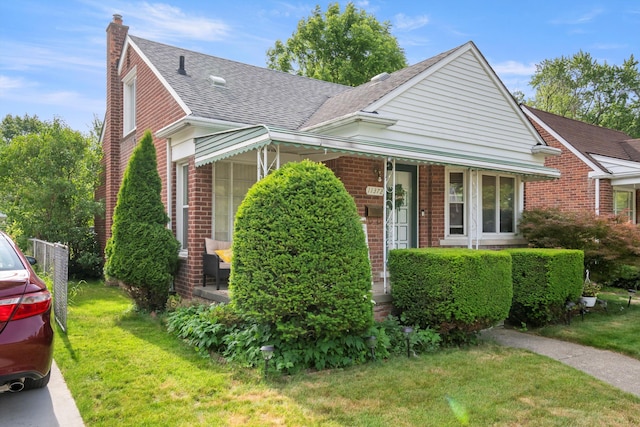 11372 Riverdale Ave, Redford, MI 48239 - view of front facade with brick siding, a chimney, a shingled roof, and a front lawn