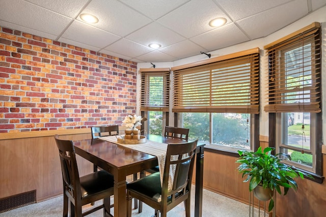 11372 Riverdale Ave, Redford, MI 48239 - dining room featuring a paneled ceiling, wood walls, and light carpet