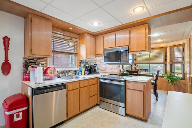 11372 Riverdale Ave, Redford, MI 48239 - kitchen featuring appliances with stainless steel finishes, a drop ceiling, tasteful backsplash, light countertops, and pendant lighting