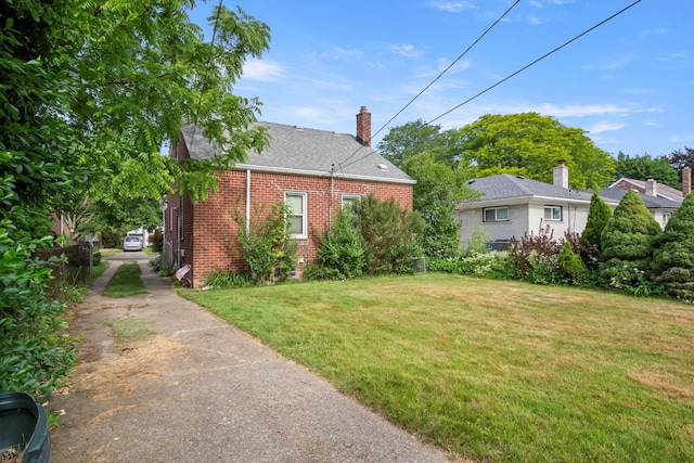 11372 Riverdale Ave, Redford, MI 48239 - view of home's exterior featuring brick siding, a lawn, driveway, roof with shingles, and a chimney