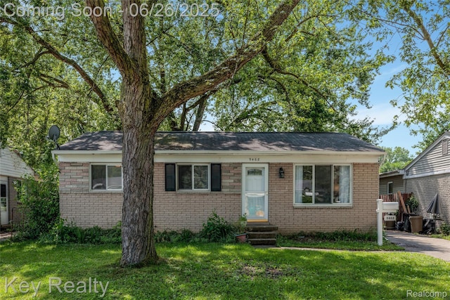 9468 Washington St, Romulus, MI 48174 - bungalow-style home with entry steps, brick siding, and a front lawn