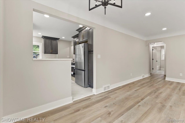 24611 Kenosha St, Oak Park, MI 48237 - unfurnished living room with light wood-style floors, recessed lighting, and arched walkways