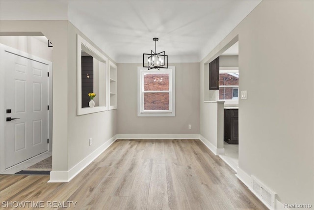 24611 Kenosha St, Oak Park, MI 48237 - unfurnished dining area with light wood-style floors and a chandelier