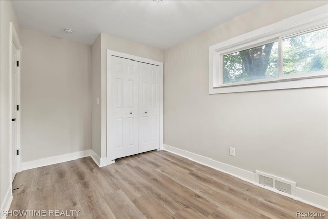 24611 Kenosha St, Oak Park, MI 48237 - unfurnished bedroom with light wood-style flooring and a closet