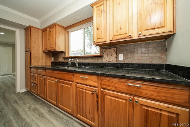 3911 Thomas Ave, Berkley, MI 48072 - kitchen featuring wood finished floors, tasteful backsplash, ornamental molding, dark stone counters, and brown cabinets