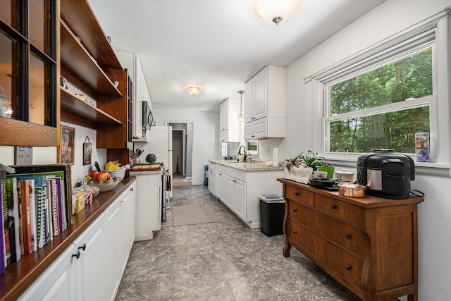 10158 US Highway 31, Berrien Springs, MI 49103 - kitchen with open shelves, stone finish floors, white cabinetry, and stainless steel stove