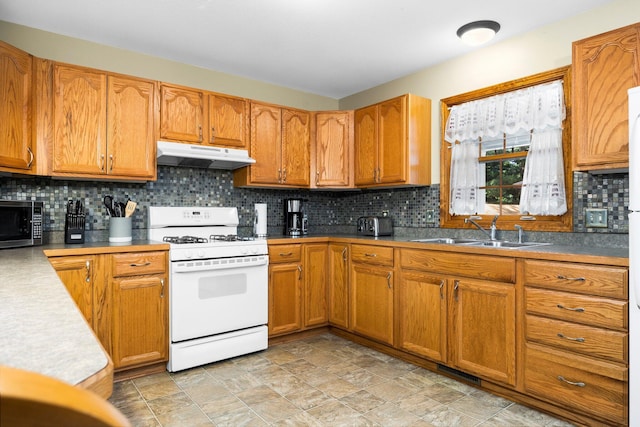 1724 N Ridge Rd, Mears, MI 49436 - kitchen with white range with gas cooktop, under cabinet range hood, stainless steel microwave, brown cabinetry, and decorative backsplash