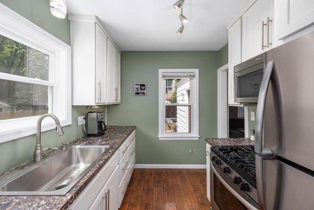 2511 Belfast Ave SE, Grand Rapids, MI 49507 - kitchen with stainless steel appliances, dark wood finished floors, white cabinets, and dark stone counters
