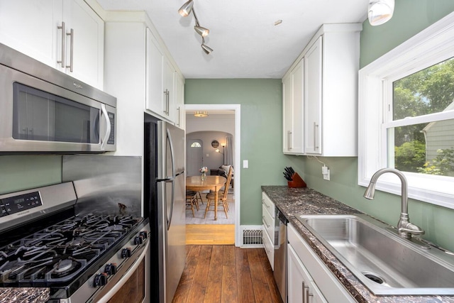 2511 Belfast Ave SE, Grand Rapids, MI 49507 - kitchen with appliances with stainless steel finishes, white cabinets, and dark wood-style floors
