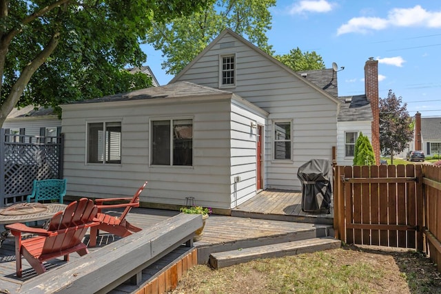 2511 Belfast Ave SE, Grand Rapids, MI 49507 - rear view of house featuring a wooden deck, a chimney, and roof with shingles