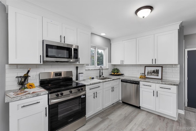 14671 Labelle St, Oak Park, MI 48237 - kitchen featuring appliances with stainless steel finishes, white cabinets, light wood finished floors, backsplash, and recessed lighting