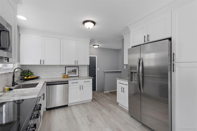 14671 Labelle St, Oak Park, MI 48237 - kitchen featuring stainless steel appliances, decorative backsplash, white cabinetry, and light wood-style floors