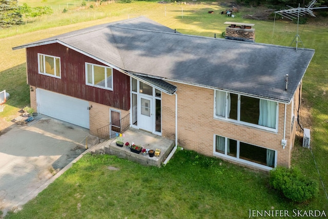 9546 Benham St NE, Cedar Springs, MI 49319 - view of front of property with a shingled roof, a chimney, driveway, and brick siding