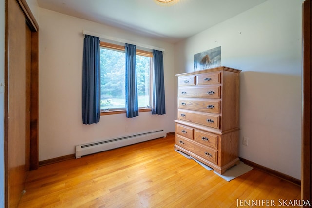 9546 Benham St NE, Cedar Springs, MI 49319 - bedroom with baseboard heating, light wood-style floors, and a closet