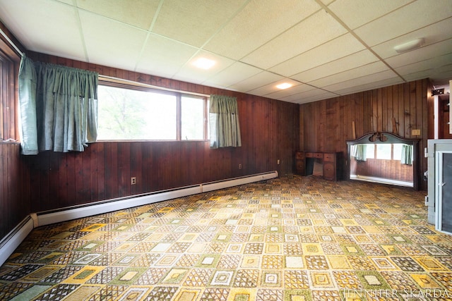 9546 Benham St NE, Cedar Springs, MI 49319 - spare room with wood walls, a baseboard heating unit, tile patterned floors, and a paneled ceiling