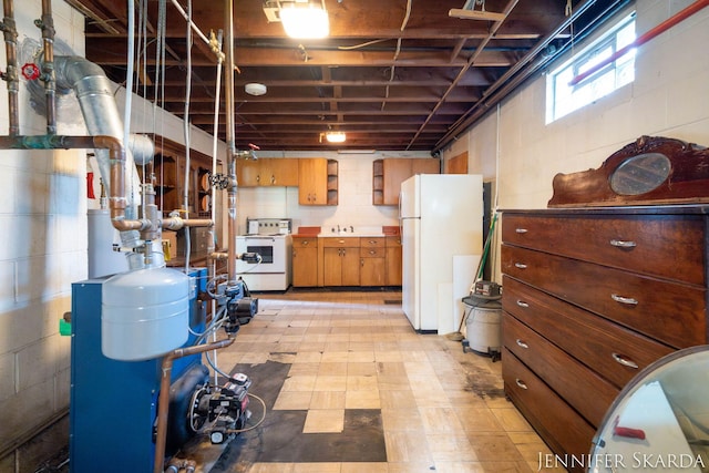 9546 Benham St NE, Cedar Springs, MI 49319 - below grade area with freestanding refrigerator, light floors, concrete block wall, and a heating unit