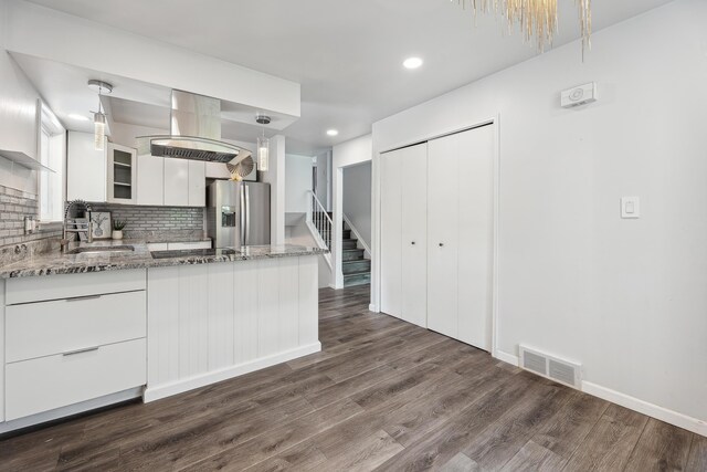 2362 Georgetown Blvd, Ann Arbor, MI 48105 - kitchen with stainless steel fridge with ice dispenser, white cabinetry, light stone counters, dark wood-type flooring, and decorative backsplash