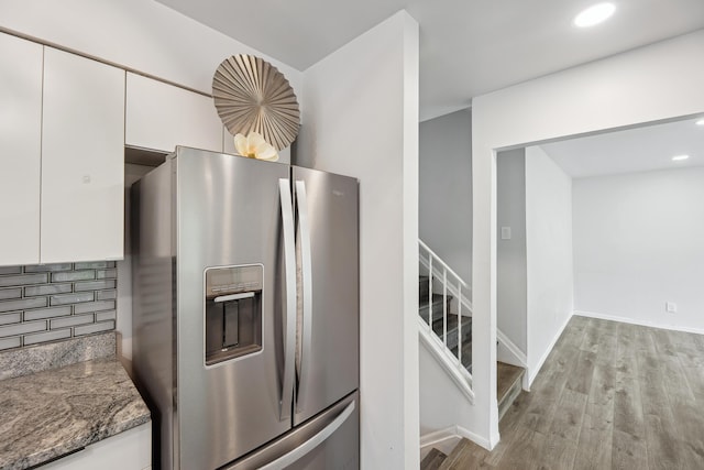 2362 Georgetown Blvd, Ann Arbor, MI 48105 - kitchen featuring stainless steel refrigerator with ice dispenser, light wood-style flooring, white cabinetry, stone countertops, and backsplash