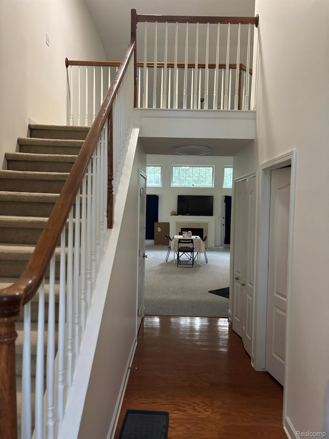 44700 Heather Ln, Canton, MI 48187 - staircase with a high ceiling, wood finished floors, and a fireplace