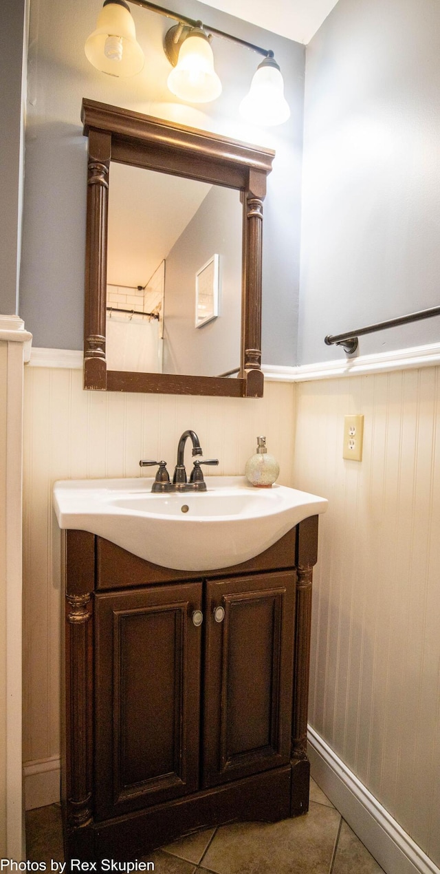 4295 S Gordon Ave, Fremont, MI 49412 - bathroom with vanity, a wainscoted wall, and tile patterned flooring