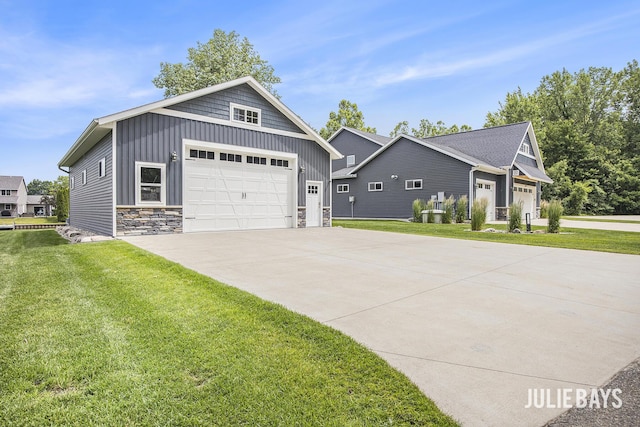 12828 Bayou Ct, Wayland, MI 49348 - view of front of home featuring stone siding, concrete driveway, board and batten siding, and a front lawn