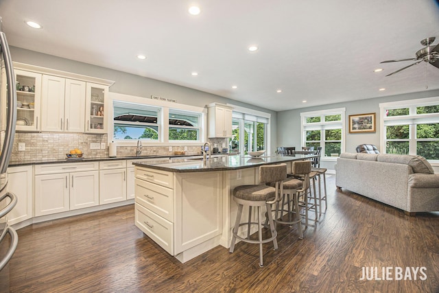 12828 Bayou Ct, Wayland, MI 49348 - kitchen featuring open floor plan, recessed lighting, decorative backsplash, dark wood-style floors, and a center island with sink