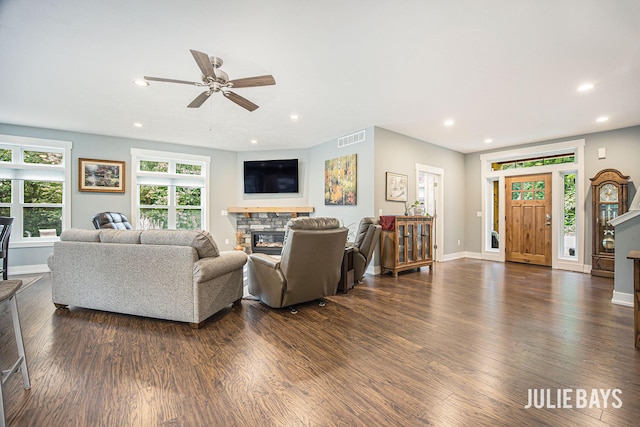 12828 Bayou Ct, Wayland, MI 49348 - living room featuring dark wood-style floors, a stone fireplace, ceiling fan, and recessed lighting