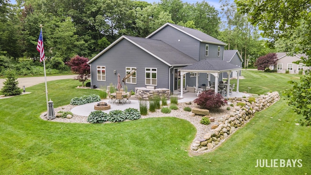 12828 Bayou Ct, Wayland, MI 49348 - back of house with a fire pit, a patio, a lawn, a gazebo, and view of wooded area