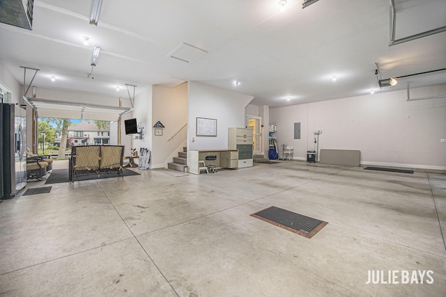 12828 Bayou Ct, Wayland, MI 49348 - garage with stainless steel fridge, electric panel, and a garage door opener