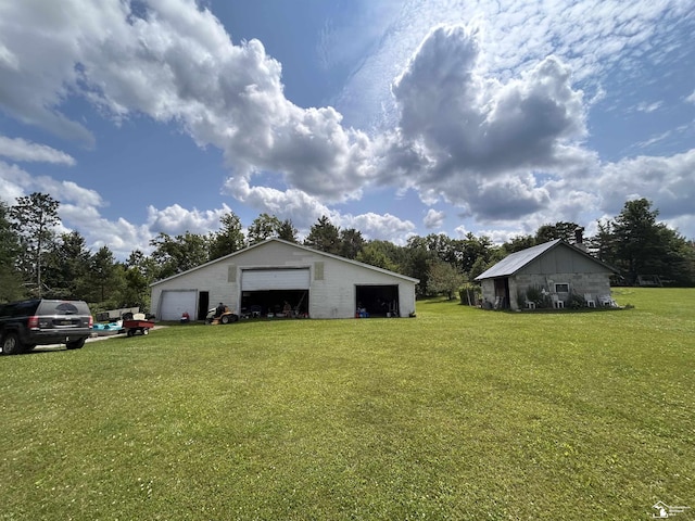 1645 N M-65 Rd, Curran, MI 48728 - view of green lawn featuring a garage and an outbuilding