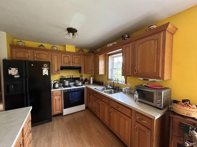 1645 N M-65 Rd, Curran, MI 48728 - kitchen featuring black refrigerator with ice dispenser, gas range gas stove, under cabinet range hood, light countertops, and light wood finished floors